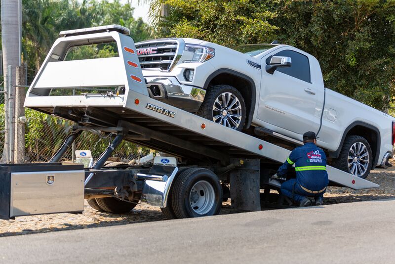 A pickup truck winched onto the bed of a flatbed tow truck
